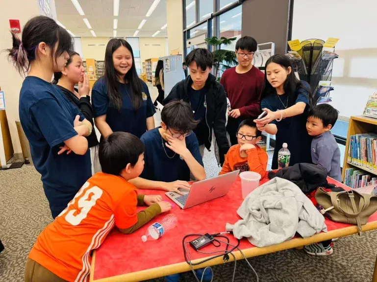 Volunteer tutors guiding students during a library session